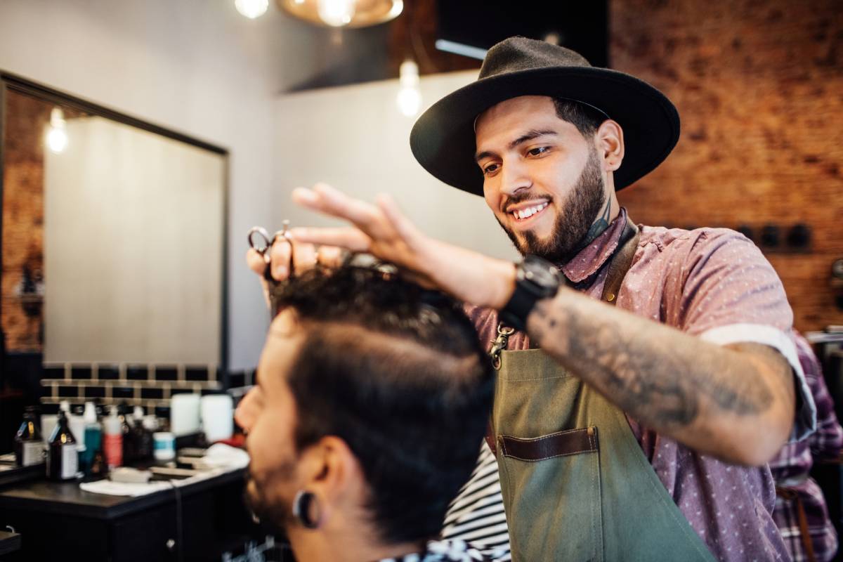 Barber small business owner cutting man's hair