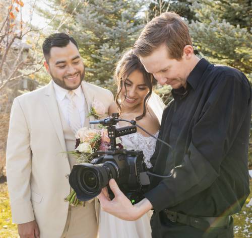 Wedding photographer showing images to bride and grrom.