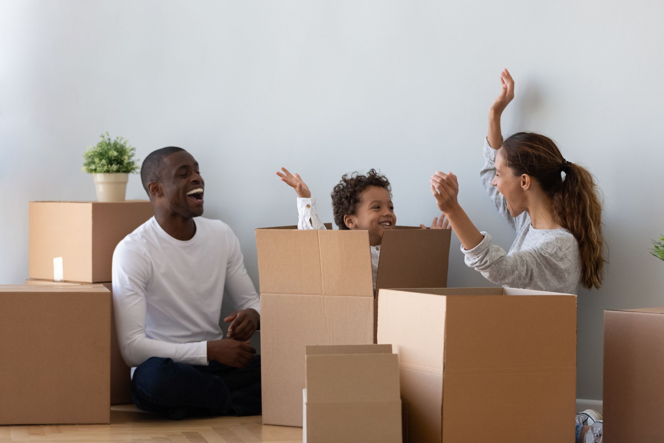 Familia jugando en cajas de mudanza vacías