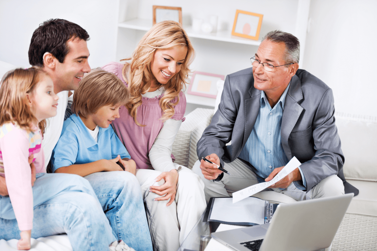 A father, mother & 2 young kids speaking with a male lawyer about creating an estate planning Trust.