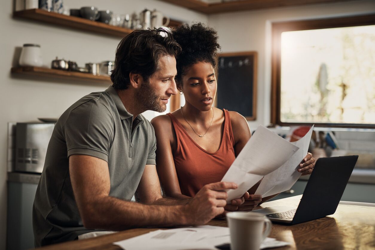 Pareja joven mirando un documento de testamento en vida en su cocina