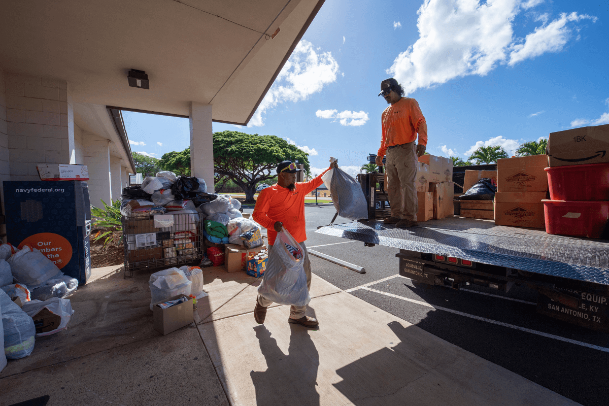 Los contratistas de Pacific Missile Range Facility, Albert Niau-Kanahele y David Planas, trasladan donaciones para que se envíen a Maui para ayudar a las víctimas de incendios forestales, en Pacific Missile Range Facility, Hawái, el 13 de agosto de 2023. PMRF, ubicada en la isla de Kauai, comenzó a recolectar donaciones tras los devastadores incendios forestales en Maui. (Foto de la Marina de los EE. UU. por Lisa Ferdinando)