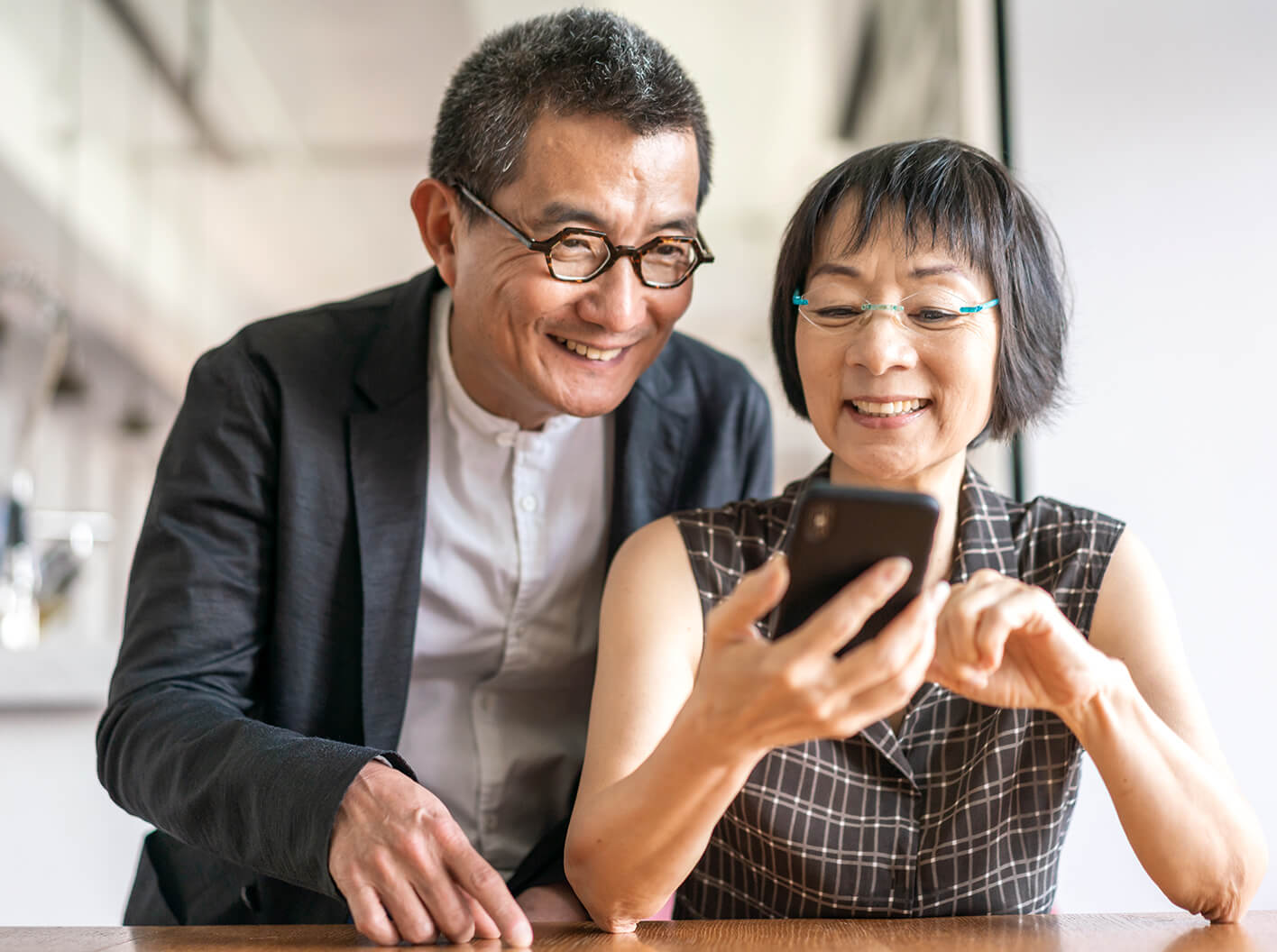 Smiling couple looking at a phone screen.