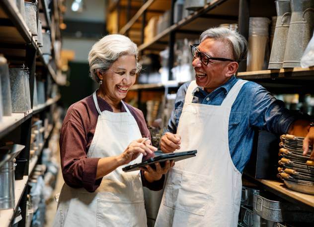 Small business owner couple talking about their estate plan in business back room.