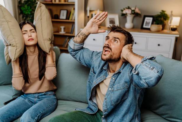 Man and woman angry with bad neighbors because of loud noises.