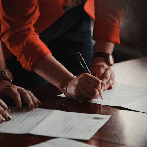 Dos mujeres revisando y firmando documentos.