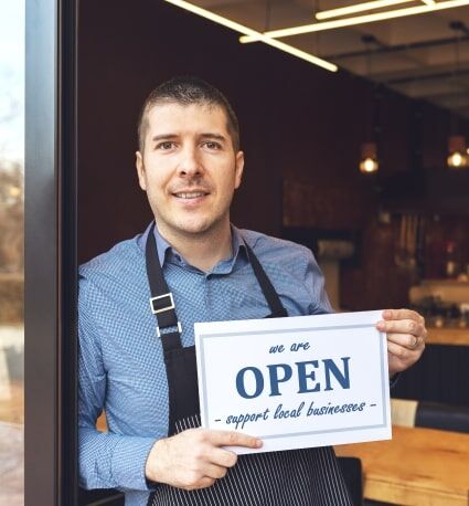 Empresario sosteniendo un cartel que dice, somos ppen - apoya a los negocios locales.