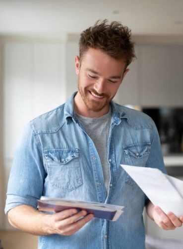 Hombre sonriendo mientras revisa su correo