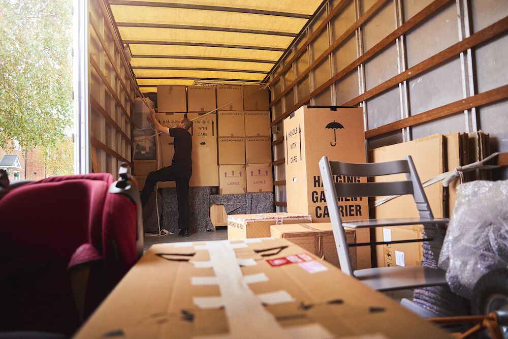 Trabajador de camión de mudanzas asegurando cajas