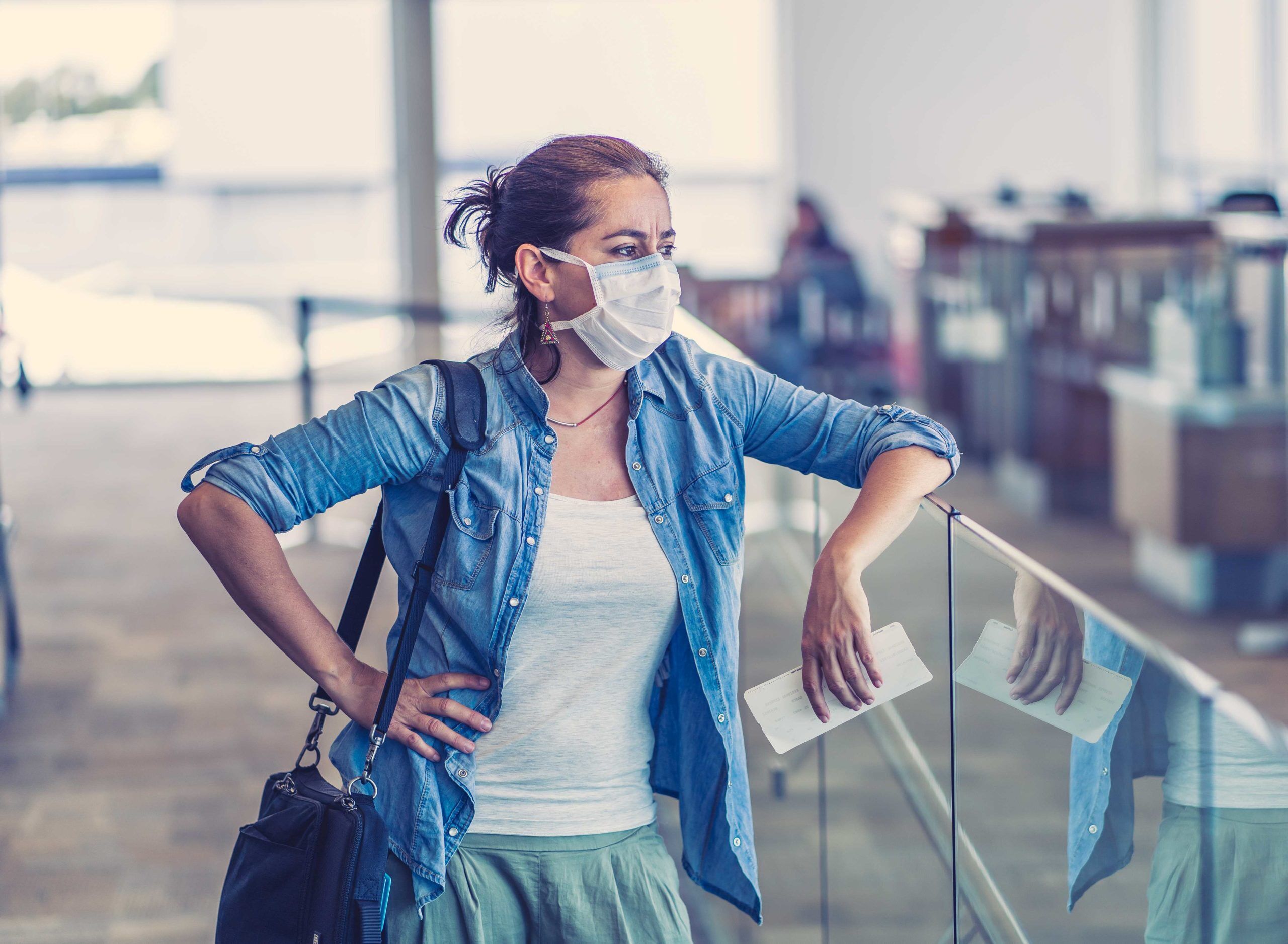 Mujer viajera en el aeropuerto con máscara