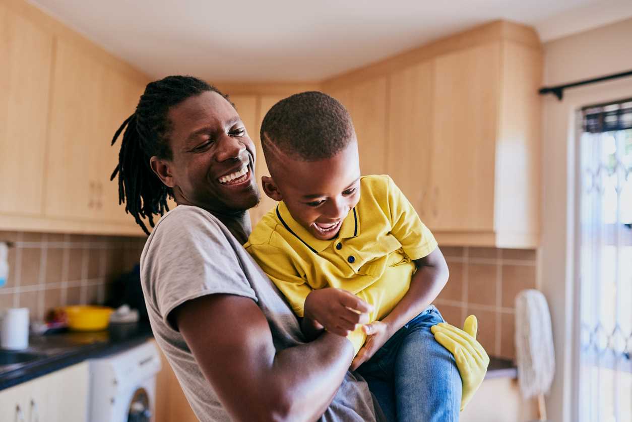 Father playing with son in kitchen