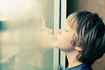 niño mirando por la ventana