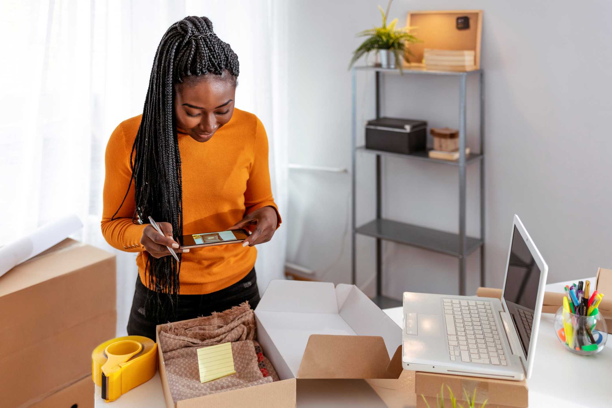 Home-based entrepreneur taking a photo of a product she is packing