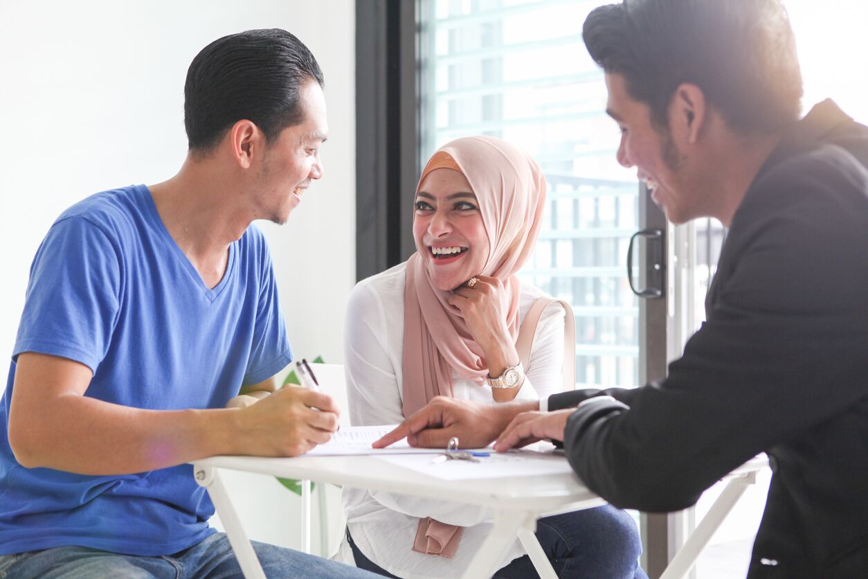 Happy man & woman preparing to sign a prenuptial agreement