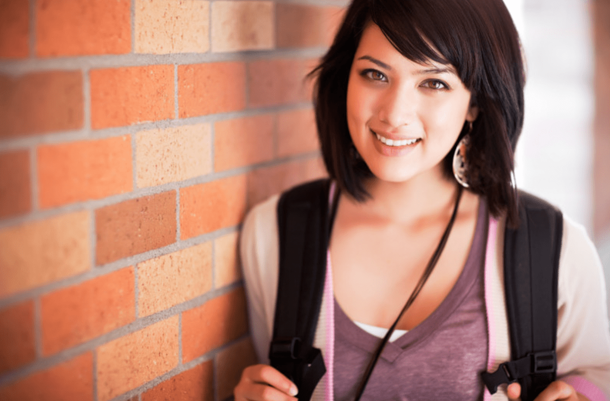 College student leaning on a wall