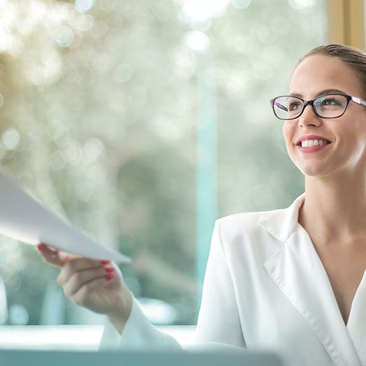 Joven sonriente aceptando un documento.