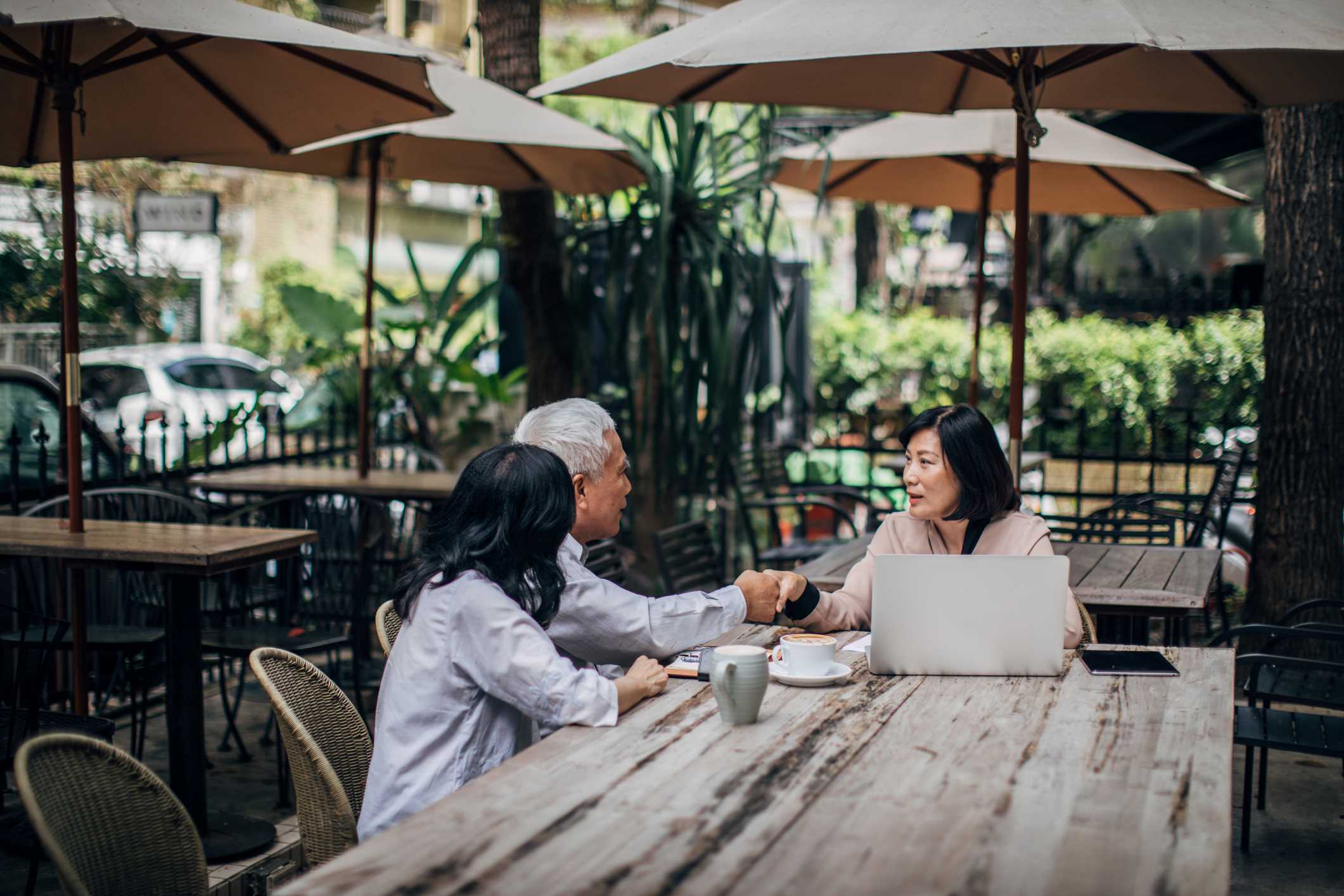 Abogado discutiendo el Plan Patrimonial y los impuestos con una pareja en un patio al aire libre