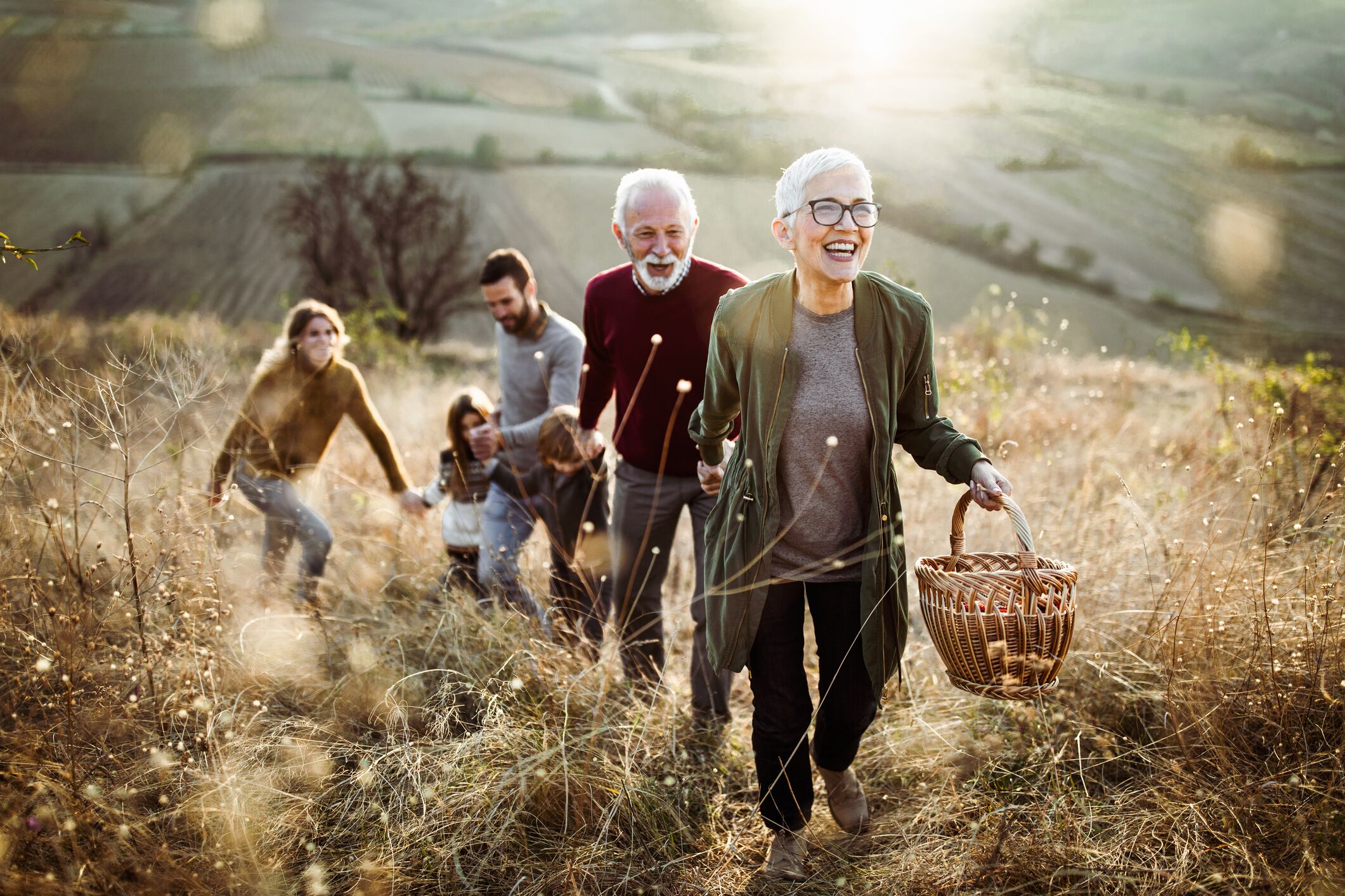 Extended family walking up a hill together for a picnic