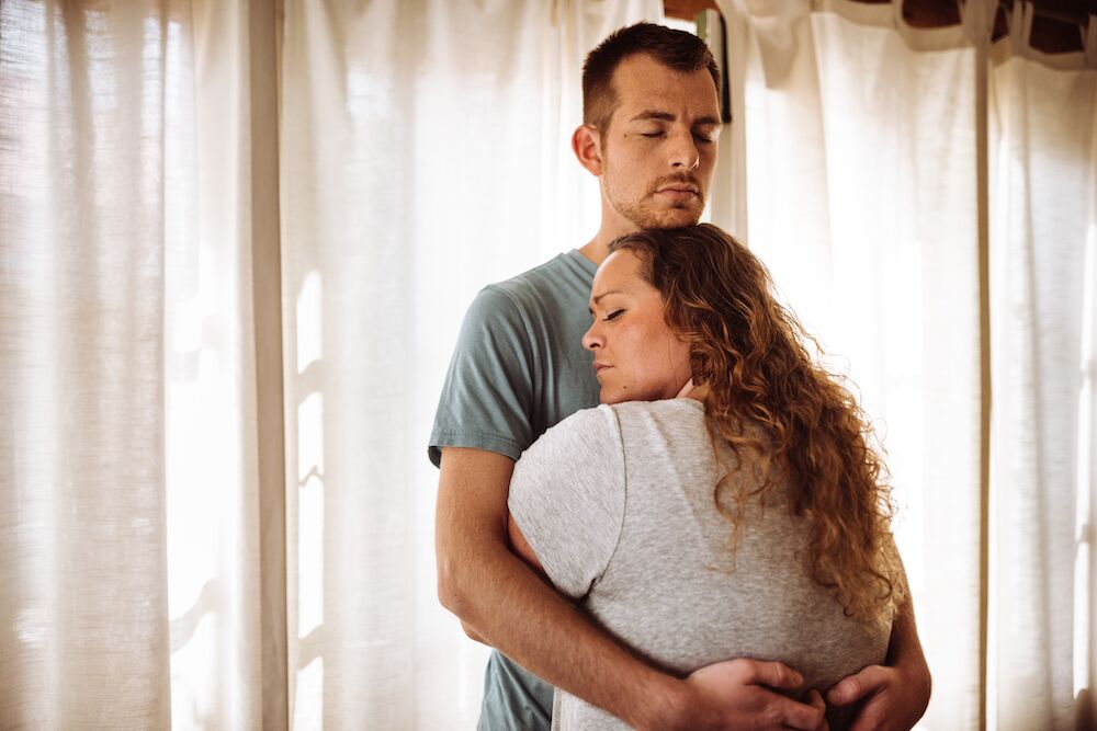 Pareja abrazándose con los ojos cerrados