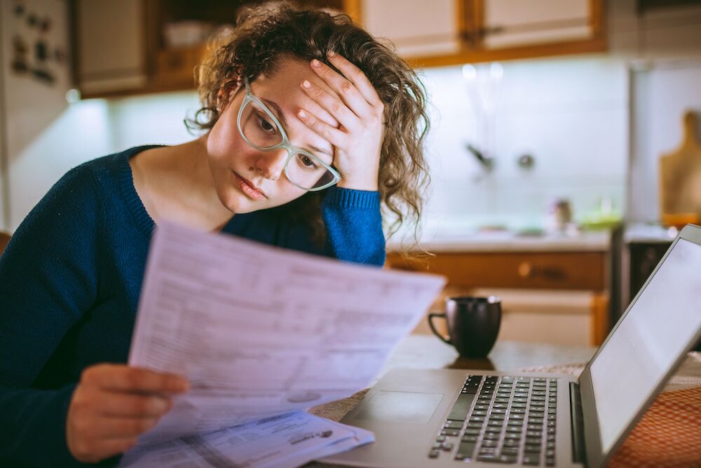 Mujer preocupante revisando una factura