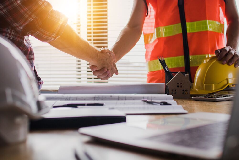 Trabajadores del proyecto de construcción dándose la mano