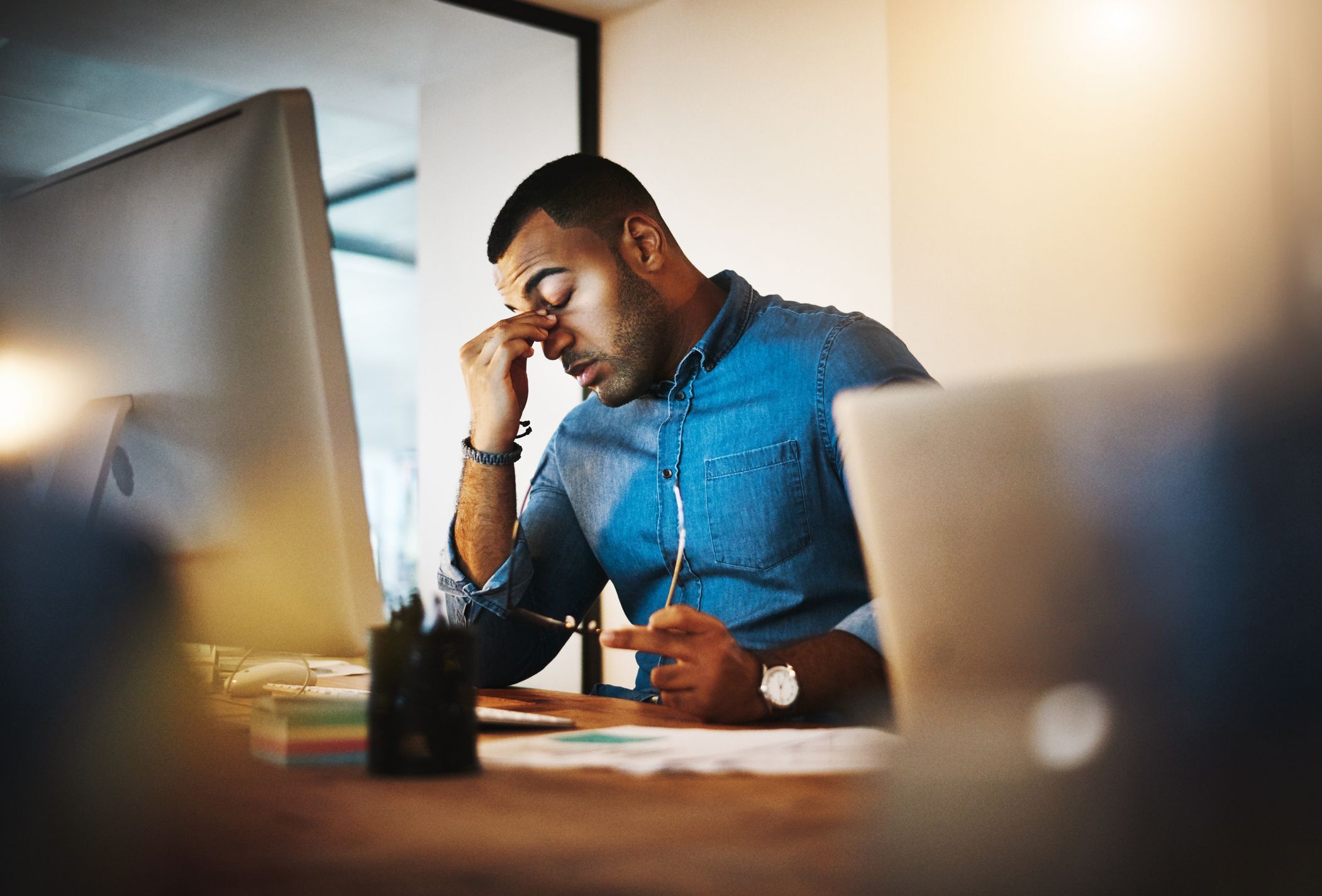 Hombre desempleado que parece estresado en el escritorio de su computadora