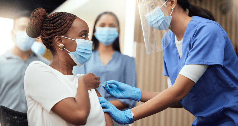 Mujer recibiendo la vacuna COVID de un trabajador de la salud