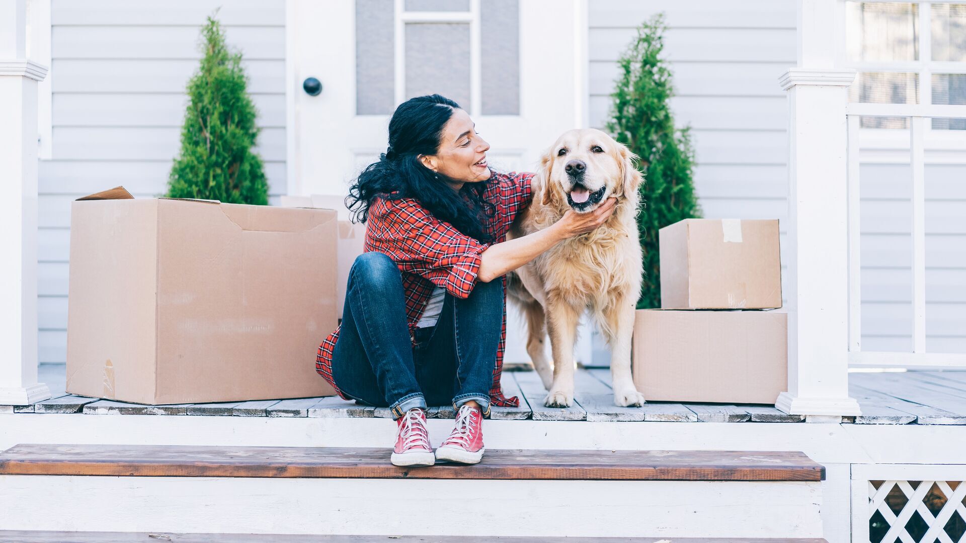 Perro y mujer en el porche de una casa