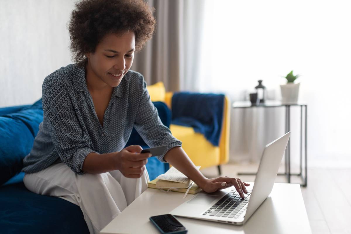 Smiling woman filing an IRS amended tax return using her laptop