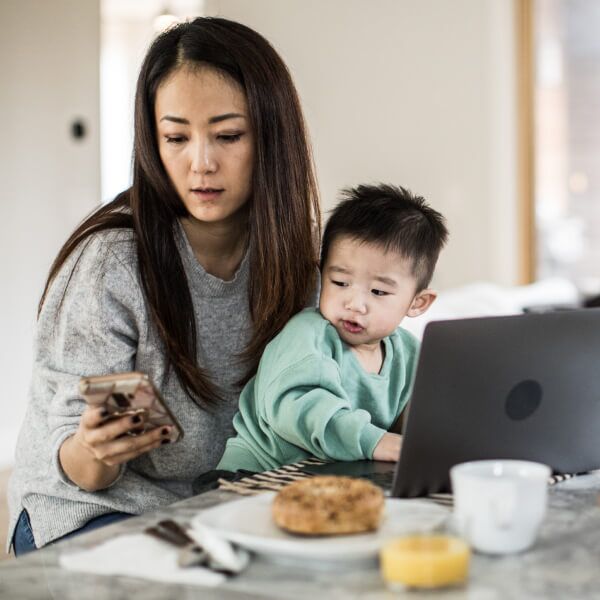 Mom researching the Child Tax Credit with son on lap