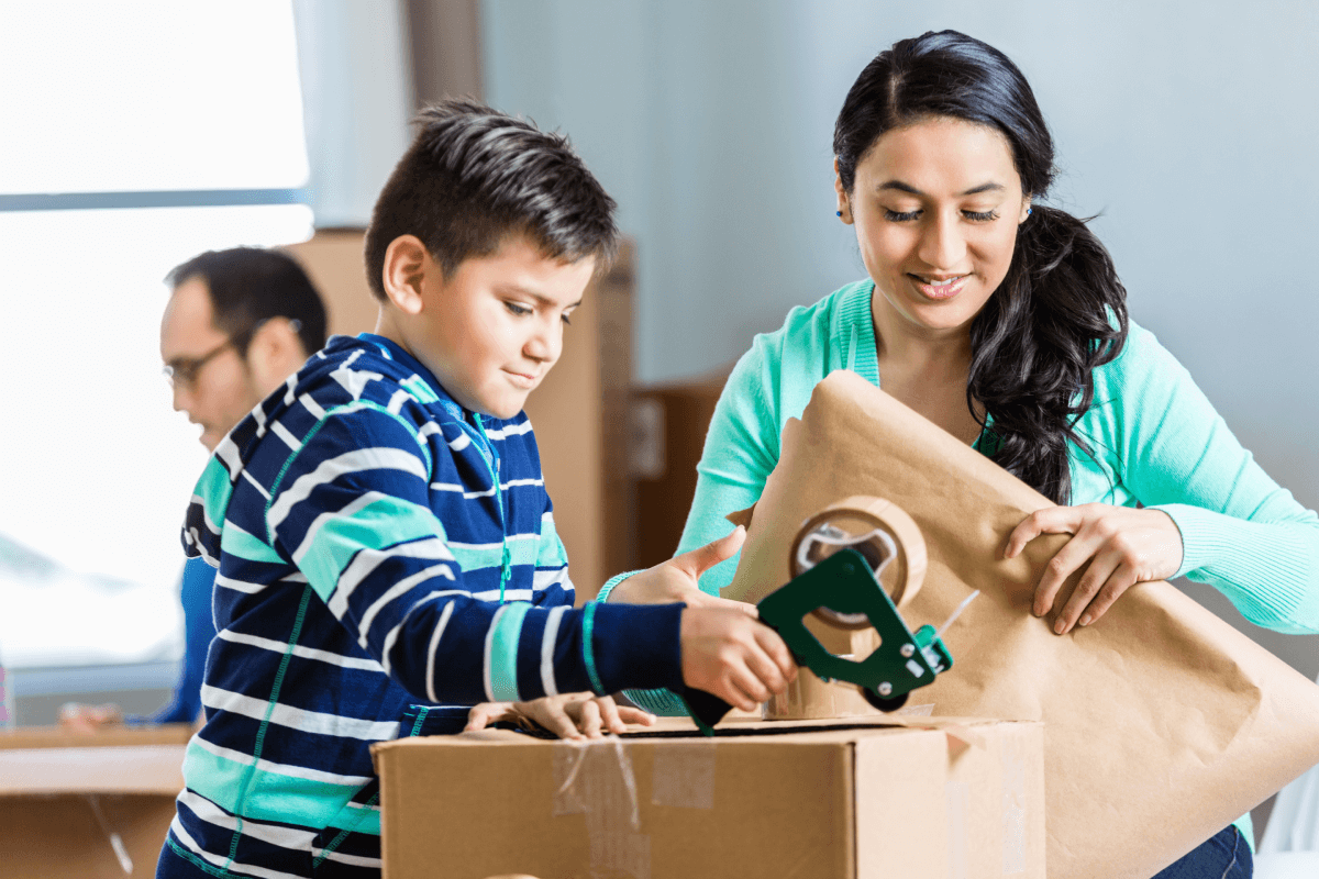 Mother and son packing moving boxes.