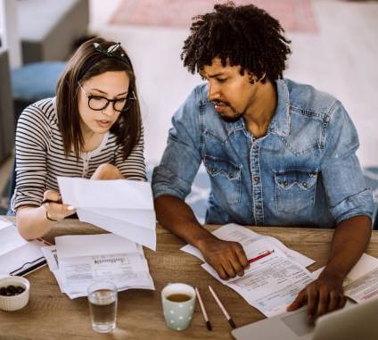 A young couple looking at a living will and trust estate planning documents.