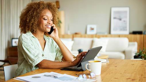 Woman purchasing a LegalShield Plan on her laptop while talking on her phone.