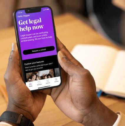 Man holding his iPhone and looking at the LegalShield Get Legal Help Now home screen