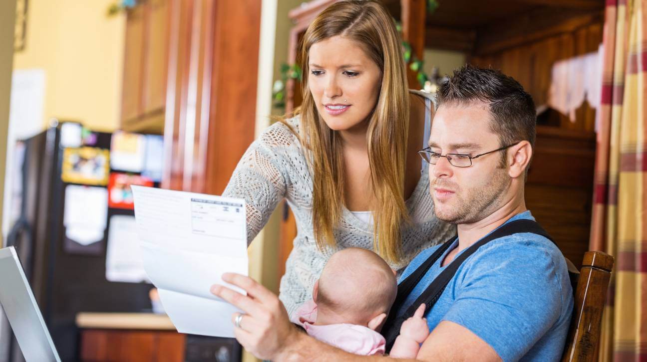 Father, mother and infant looking at a medical bill.bill dispute.