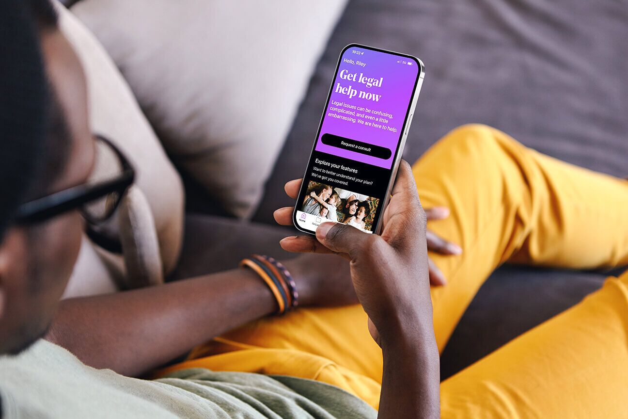 Man relaxing on a couch and using the LegalShield app.