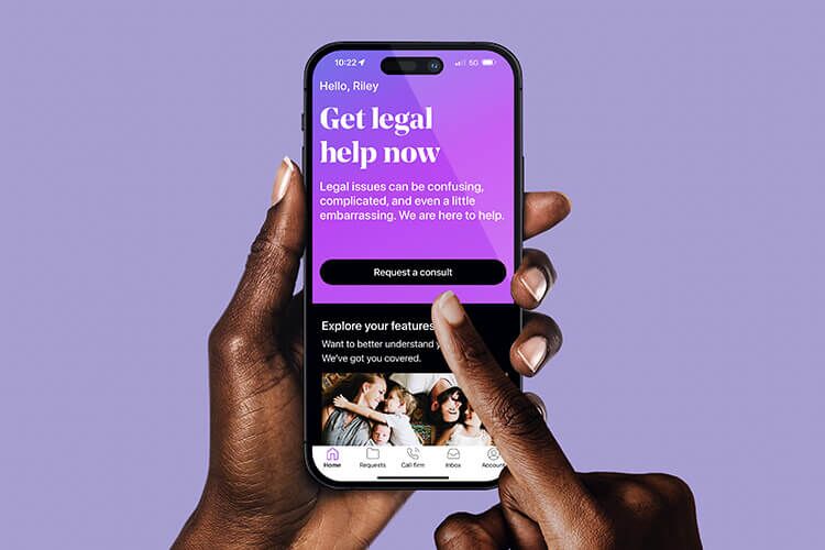 Hands navigating LegalShield app on smartphone.