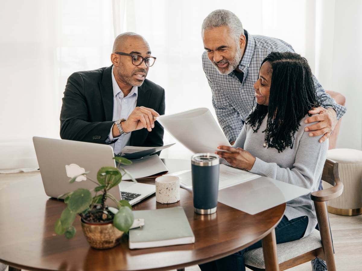 Lawyer explaining estate planning documents to a mature married couple.