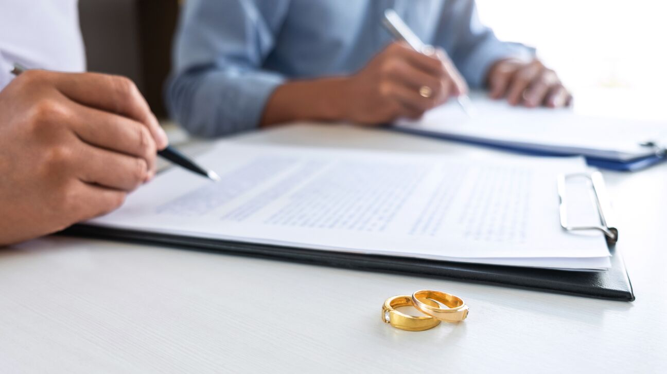 Marido y mujer firmando documentos legales de divorcio.