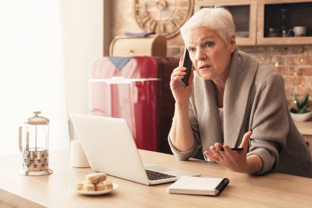 Woman trying to find a lawyer on the phone and using a laptop.