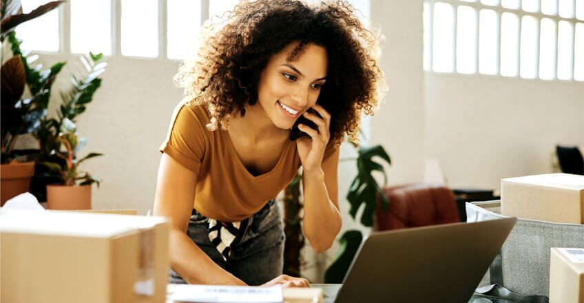 Woman looking at laptop while on the phone