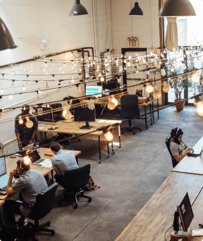 Empleados trabajando en mesas en un espacio de oficina abierto.