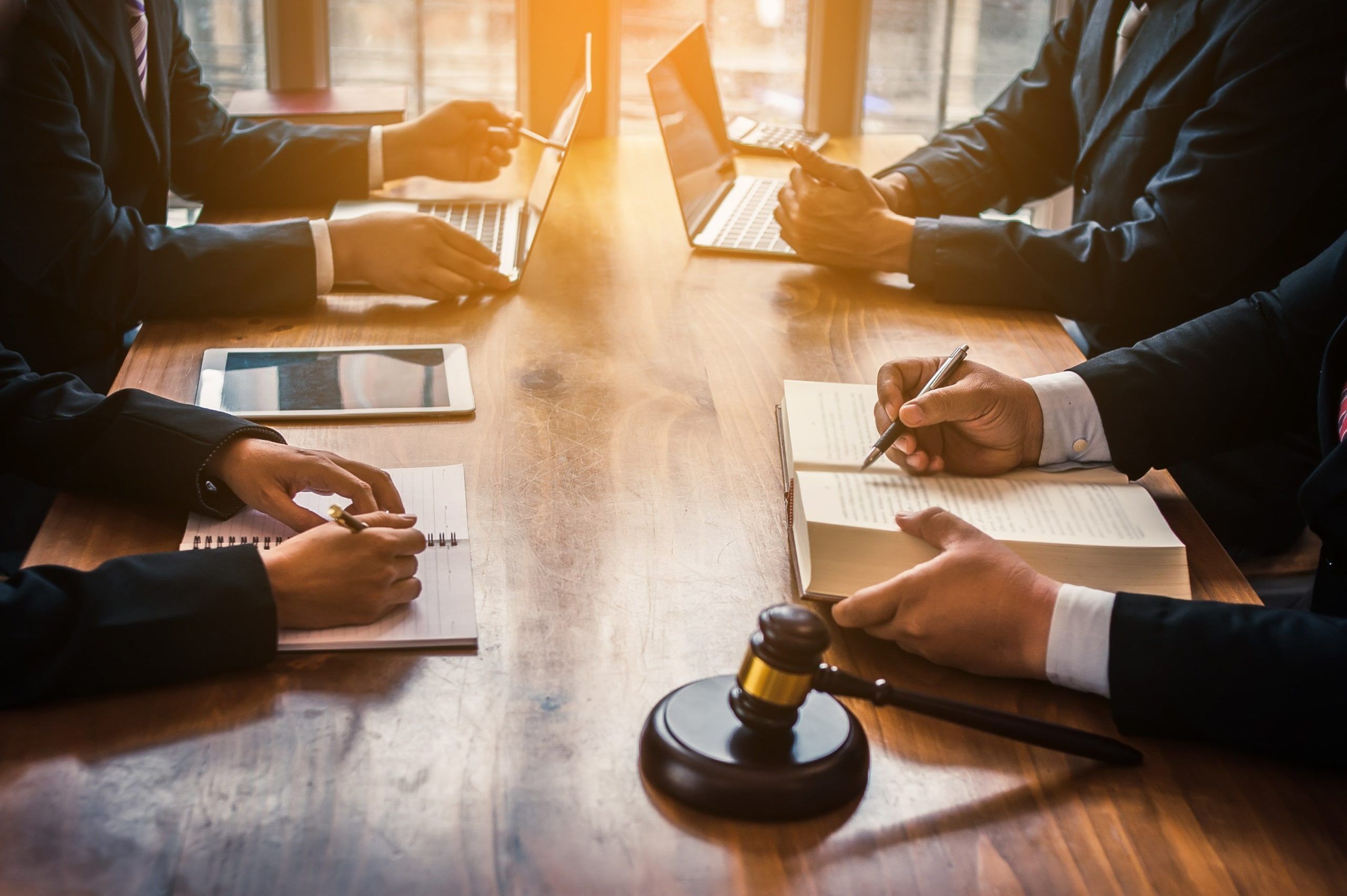 Una reunión con cuatro abogados o jueces en la mesa de una sala de conferencias.