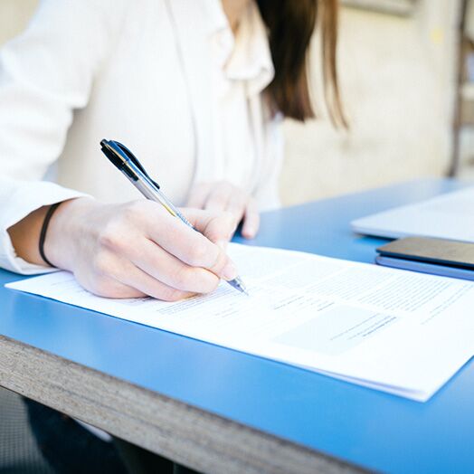 Mujer que rellena un formulario o documento legal.