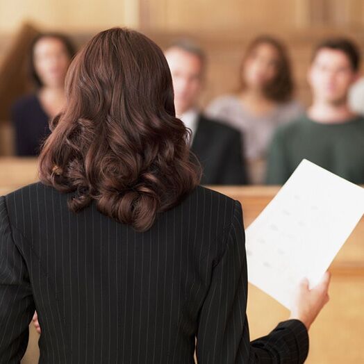 Una abogada hablando con un jurado en un tribunal.