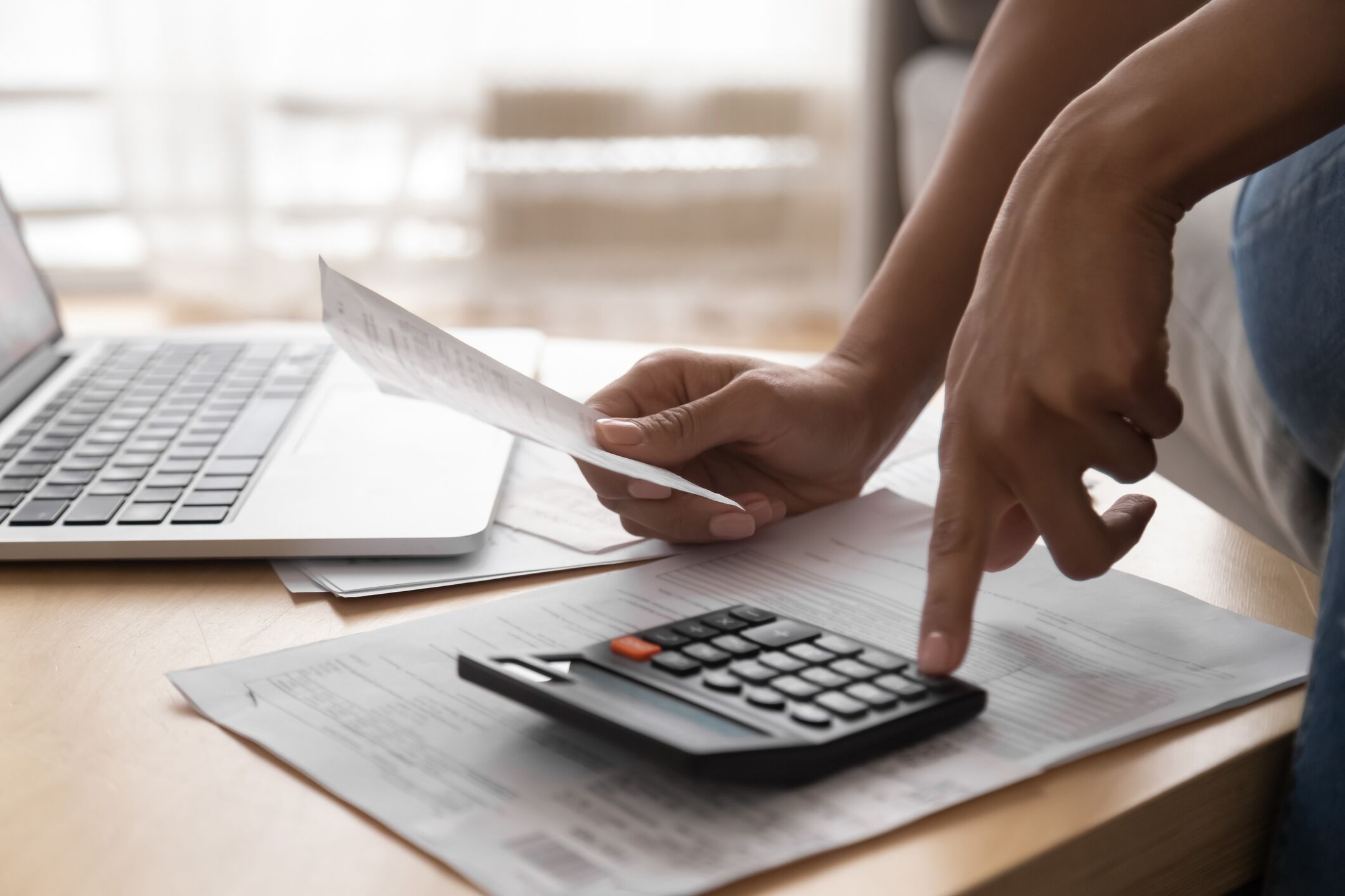 Mujer mirando el recibo y usando una calculadora