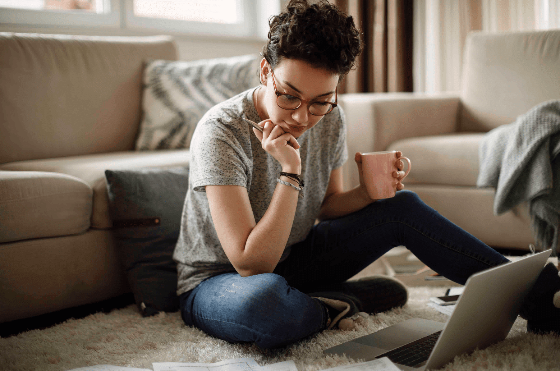 Mujer sentada en el suelo mirando su computadora