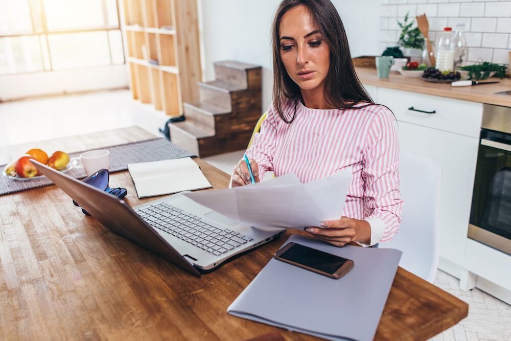 Woman working on her Last Will & Testament at her home kitchen table