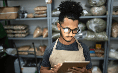 Small business owner using laptop in food storage room