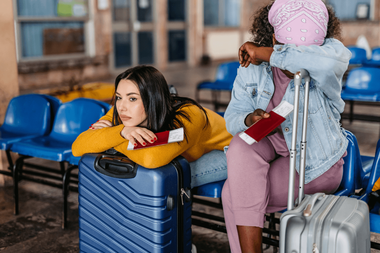 Two women in an airport upset because their flight has been delayed or cancelled.